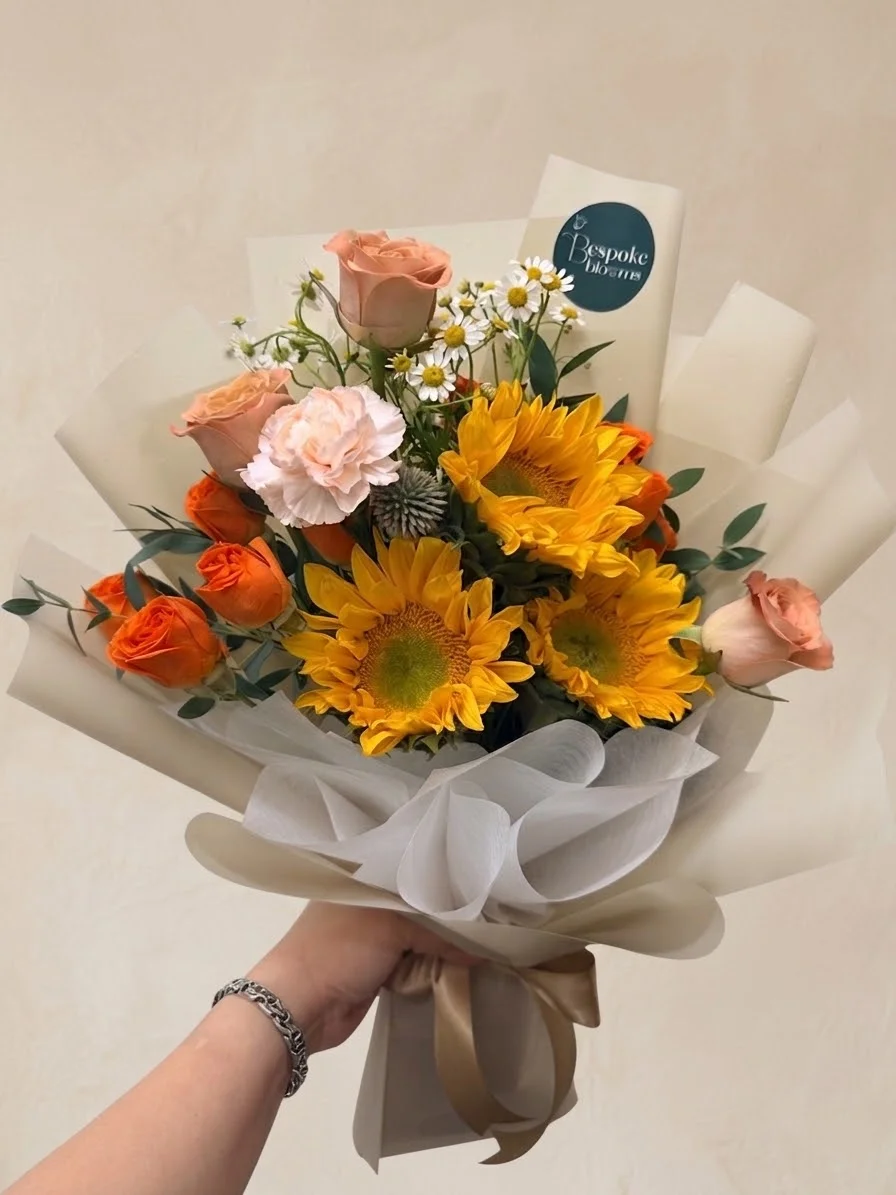 Siena - four sunflowers with peach and orange roses, a blush carnation, white chamomile and blue thistle
