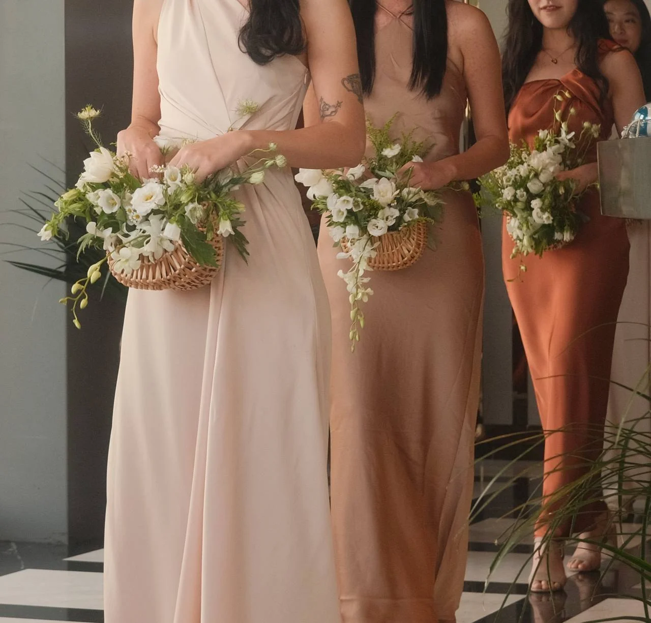 Bridesmaids holding white and green basket bouquets